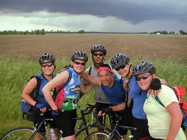 Ashley R., Jenn, Rajeev, Fred, Leah, and Kelly stand in front of not-so-far-off rainclouds in northwest Indiana.