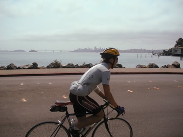 David C. bikes by the San Francisco skyline.