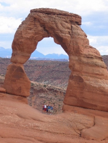 Renee, Travis, Vidya, Joe, and Funkel (Alex) hang out under Delicate Arch at Arches National Park.